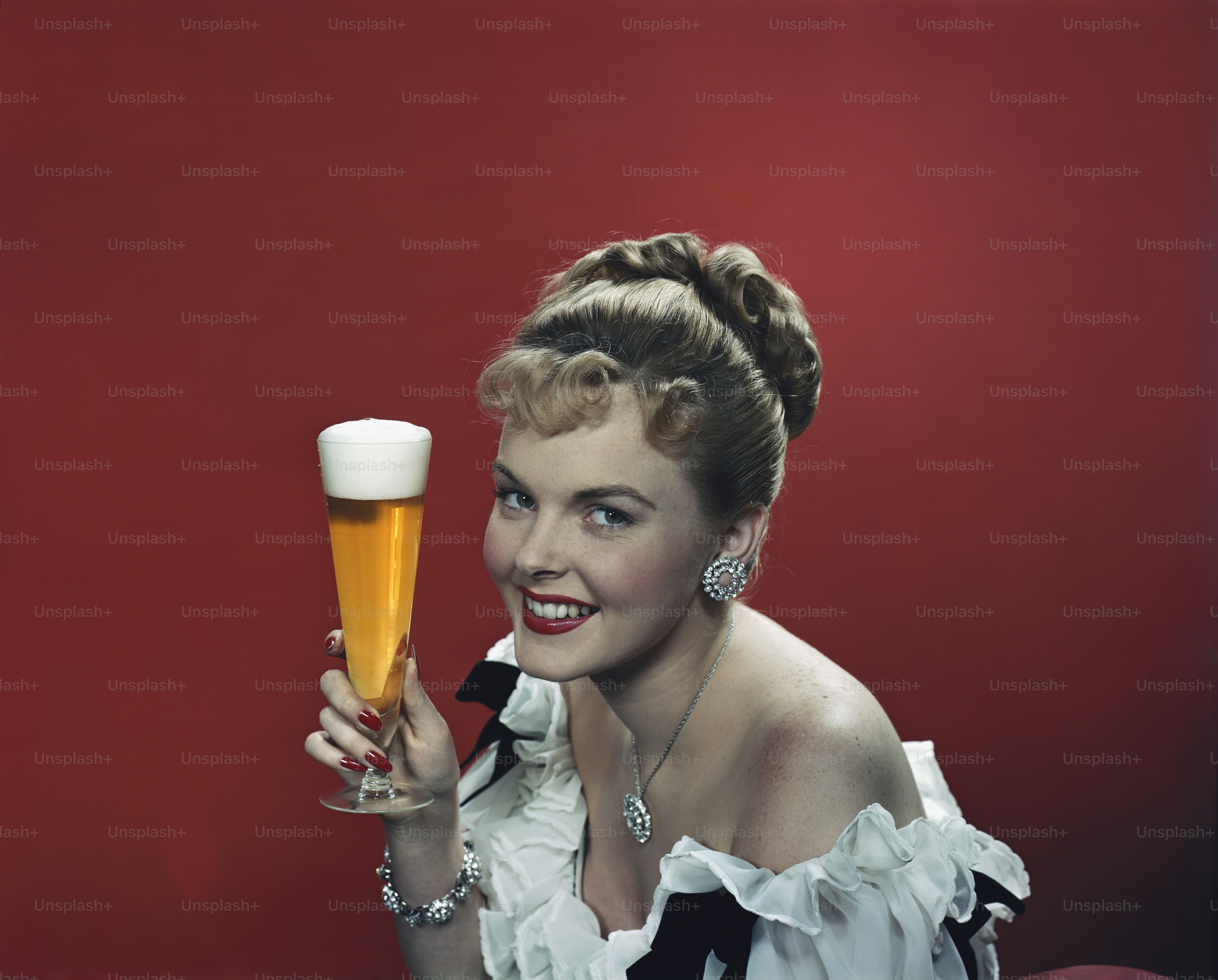 A woman in a white dress holding a glass of beer photo – Adult Image on ...