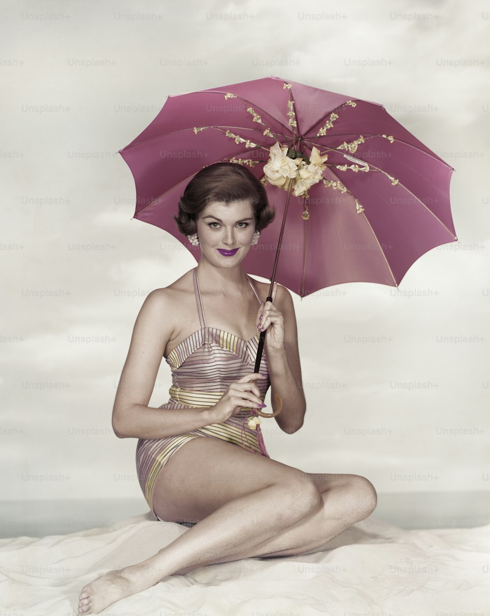 a woman in a bathing suit holding an umbrella