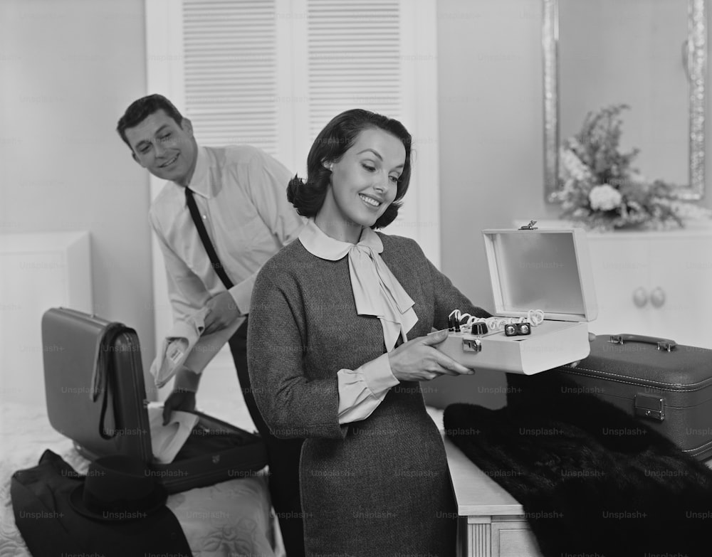 une photo en noir et blanc d’une femme ouvrant une valise