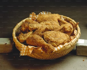 a basket filled with fried food next to a block of wood