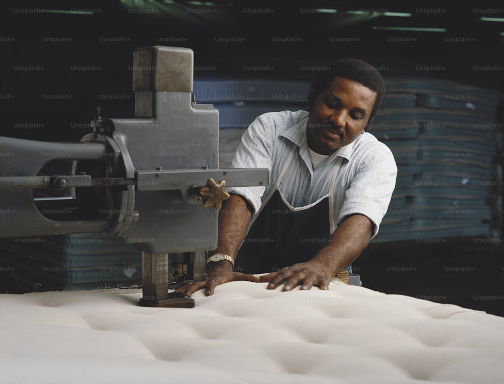 Un uomo che lavora su un materasso in una fabbrica