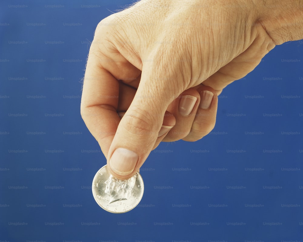 uma pessoa segurando uma moeda na mão