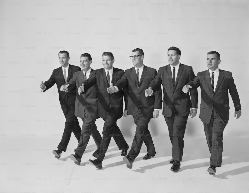 Un grupo de hombres con traje y corbata caminando juntos
