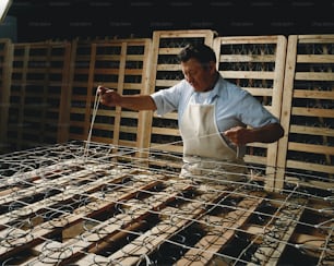 a man in an apron is working on a cage
