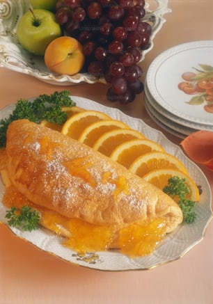 a white plate topped with an omelet covered in fruit