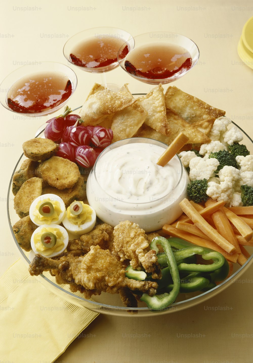a plate of food with dips, crackers, veggies, and