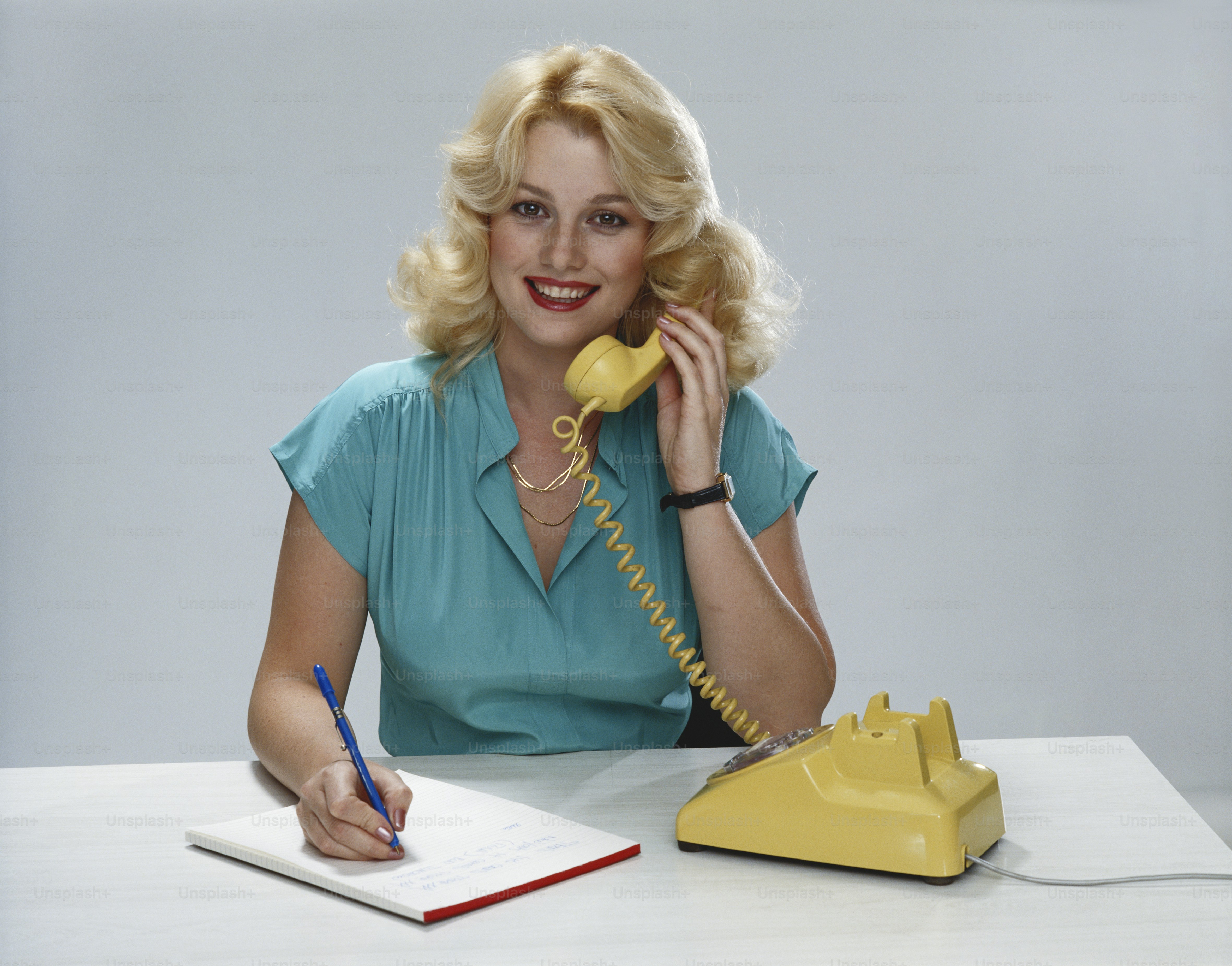 Eine Frau, die an einem Schreibtisch sitzt und telefoniert
