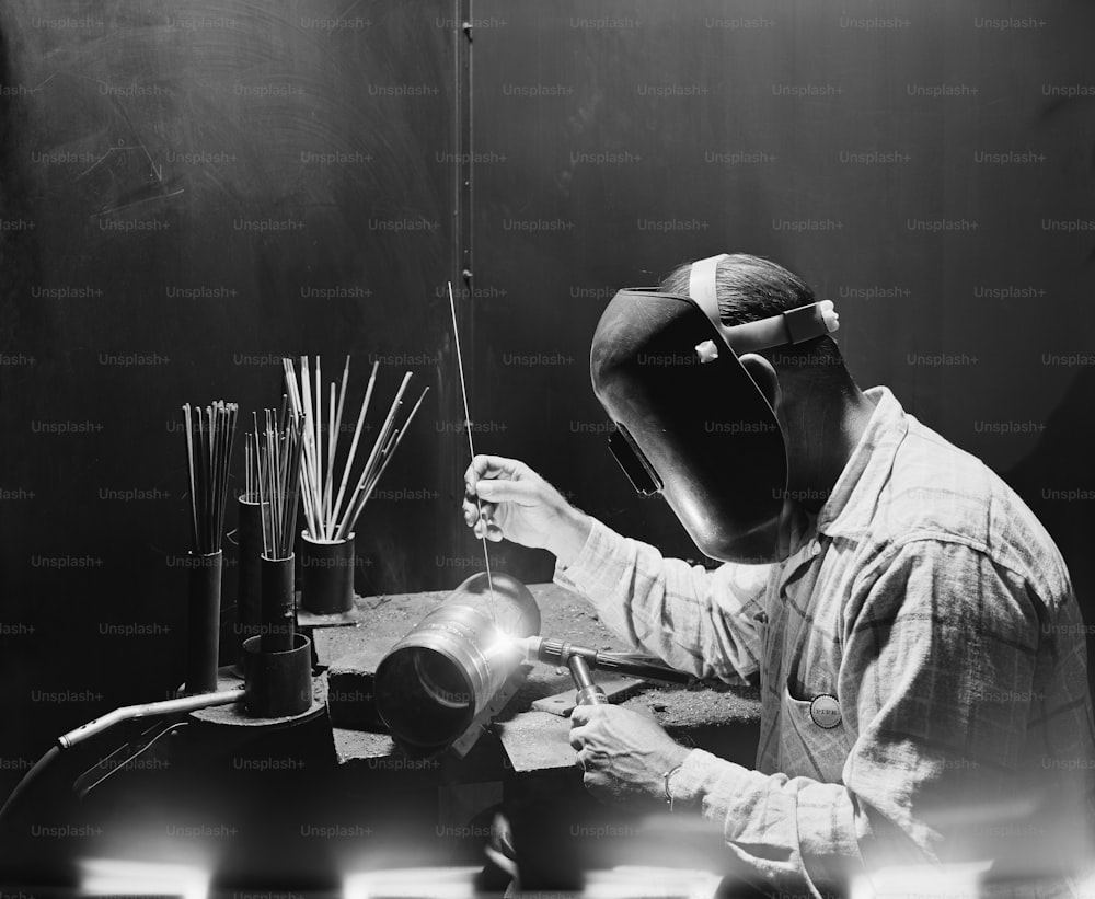 a man in a welding mask working on a piece of equipment
