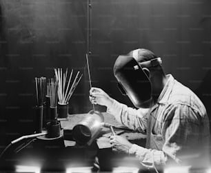 Un homme portant un masque de soudeur travaillant sur une pièce d’équipement