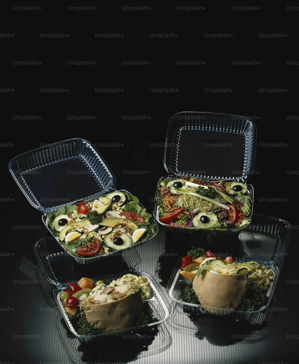 four plastic containers filled with food on top of a table