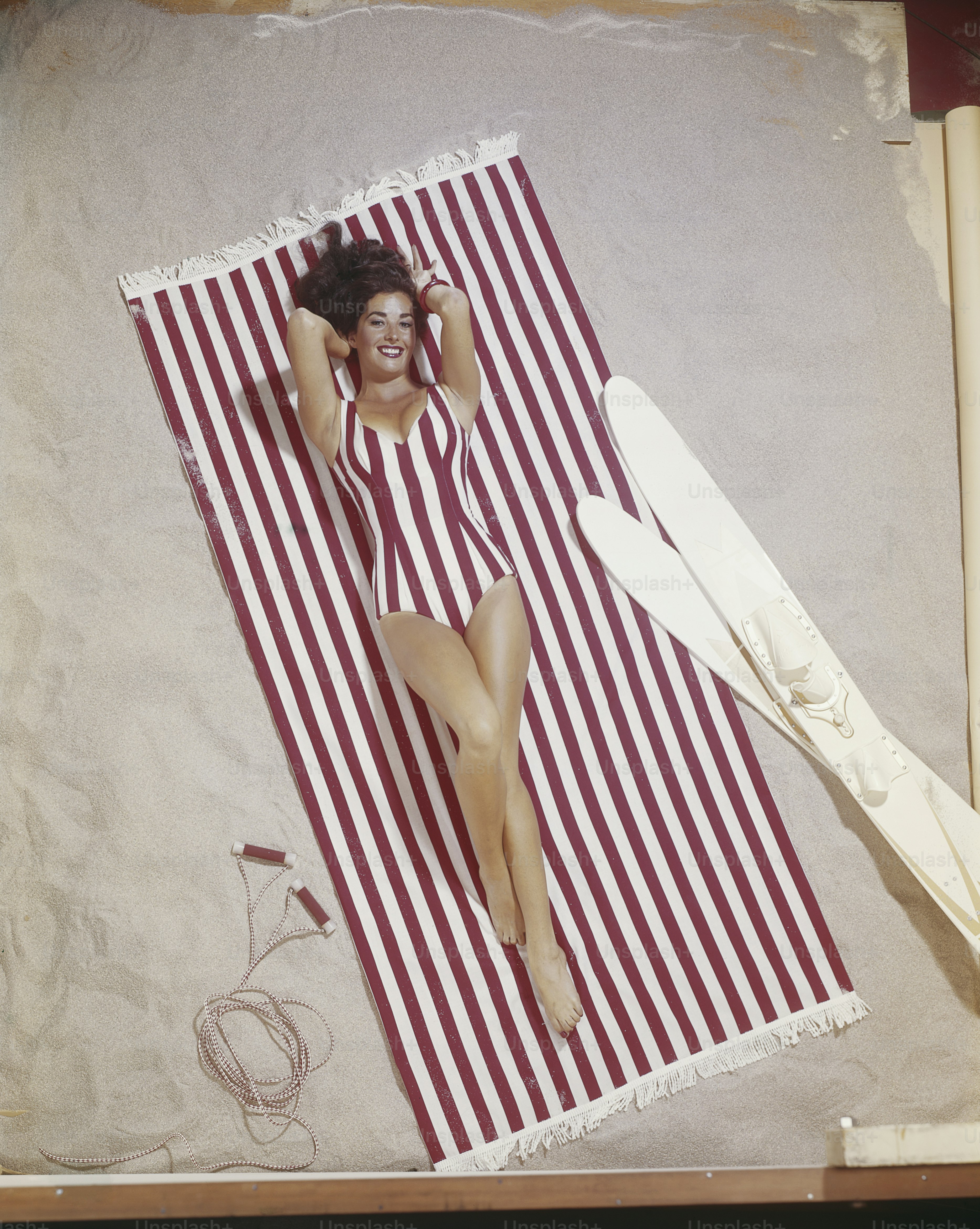 a woman in a bathing suit laying on a beach towel