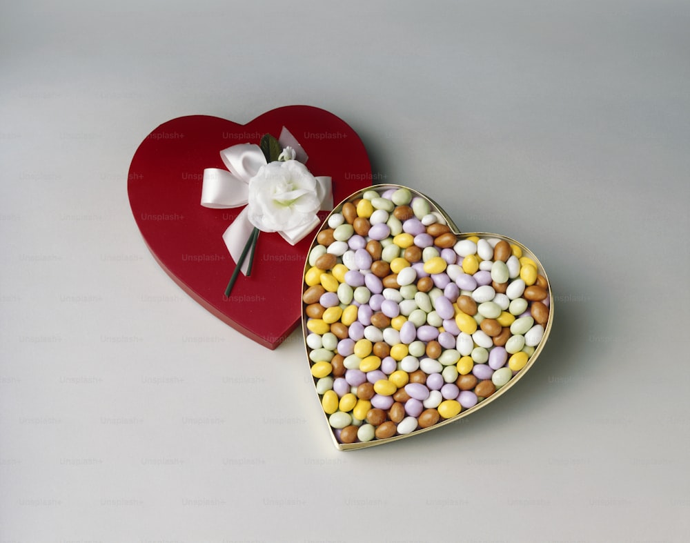 a heart shaped box of candy next to a heart shaped box of candy