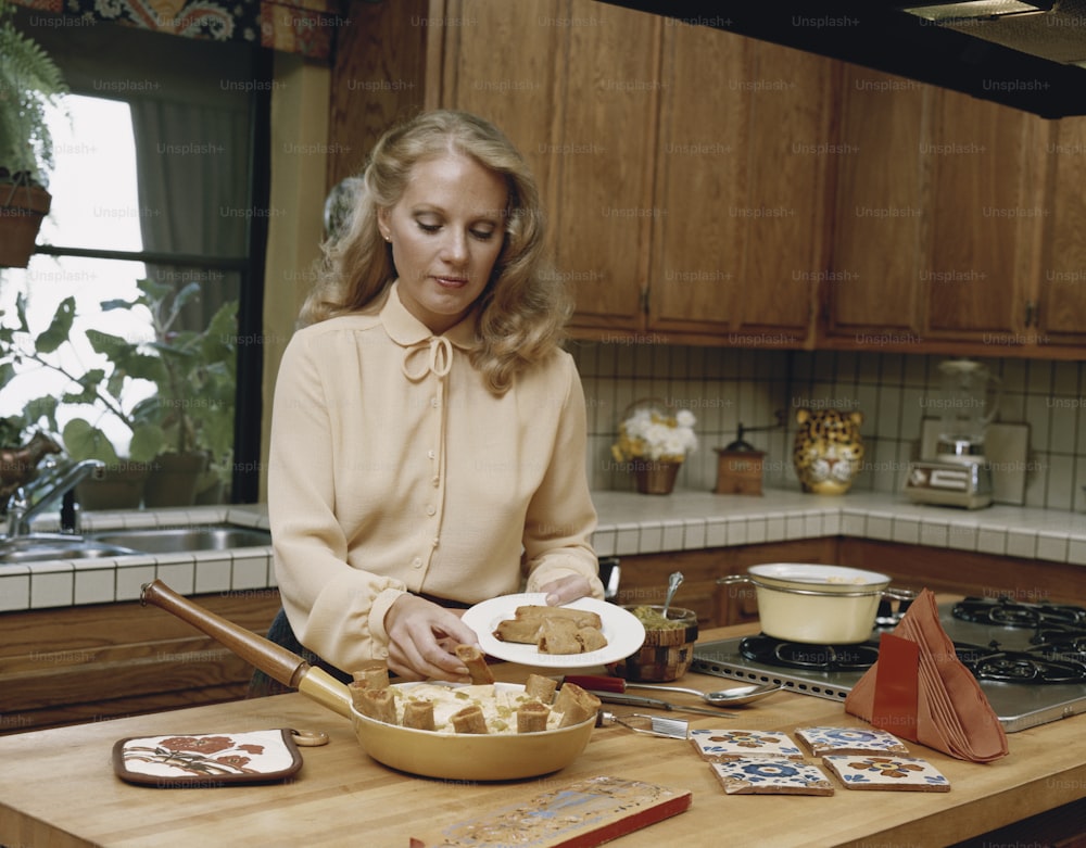 a woman sitting at a kitchen counter with a plate of food