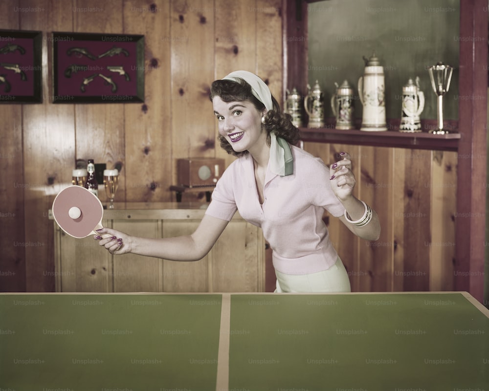 Eine Frau, die einen Tischtennisschläger in einem Raum hält