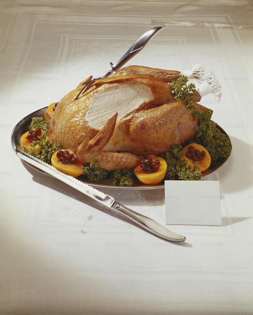 a turkey on a platter with a knife and fork
