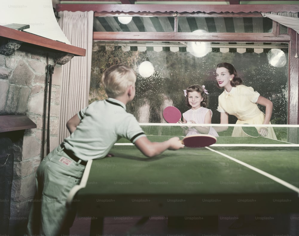 a young boy playing a game of ping pong
