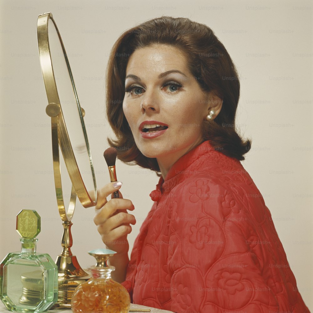 a woman in a red dress holding a knife in front of a mirror