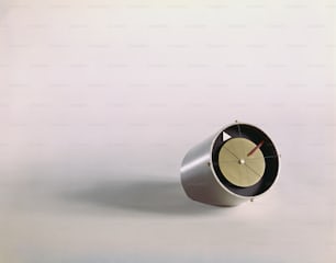 Eine Uhr, die auf einem weißen Tisch sitzt
