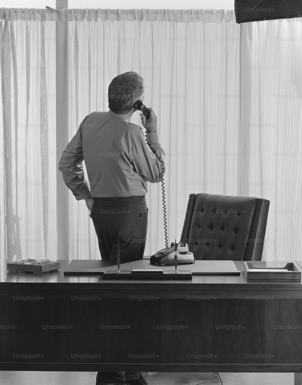um homem parado em uma mesa falando ao telefone