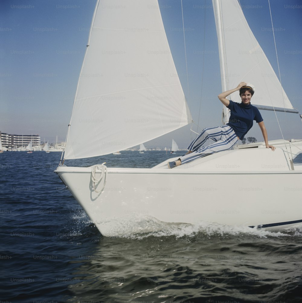 Un uomo seduto su una barca a vela nell'oceano