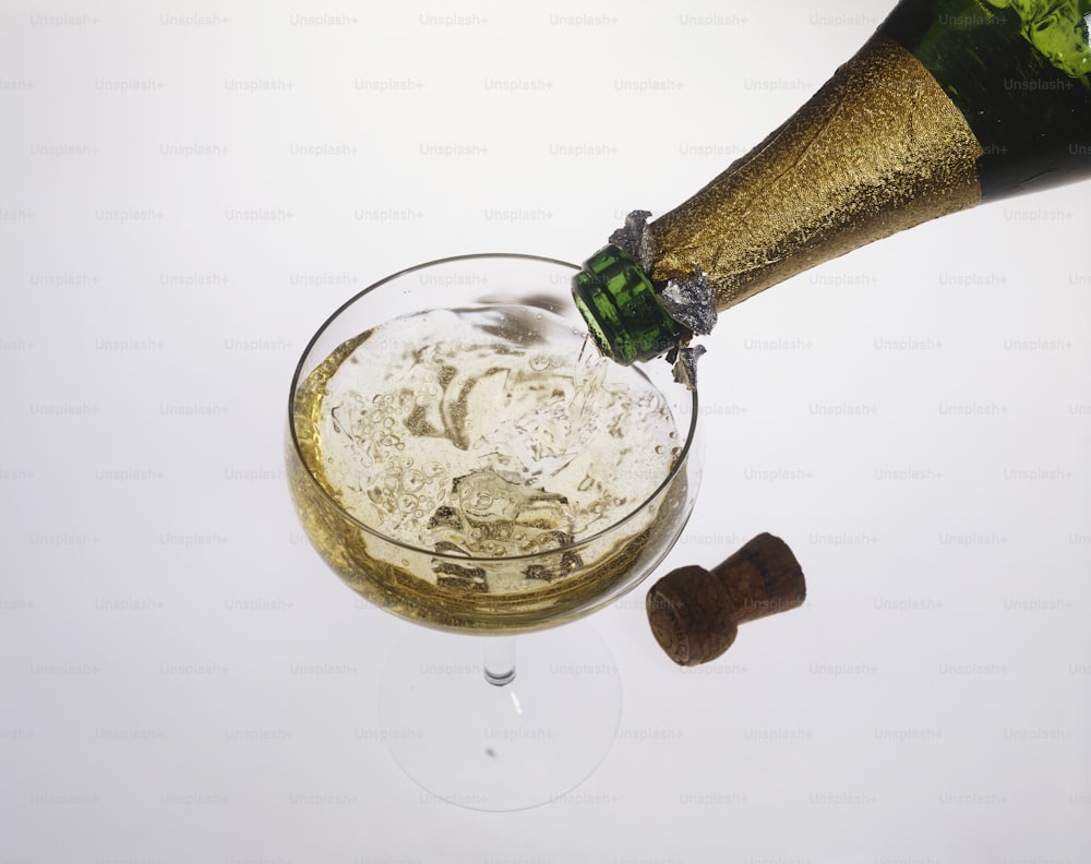 une bouteille de champagne versée dans un verre à vin