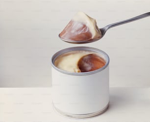a can of pudding with a spoon sticking out of it