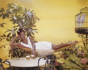 a woman laying in a hammock with a glass of beer