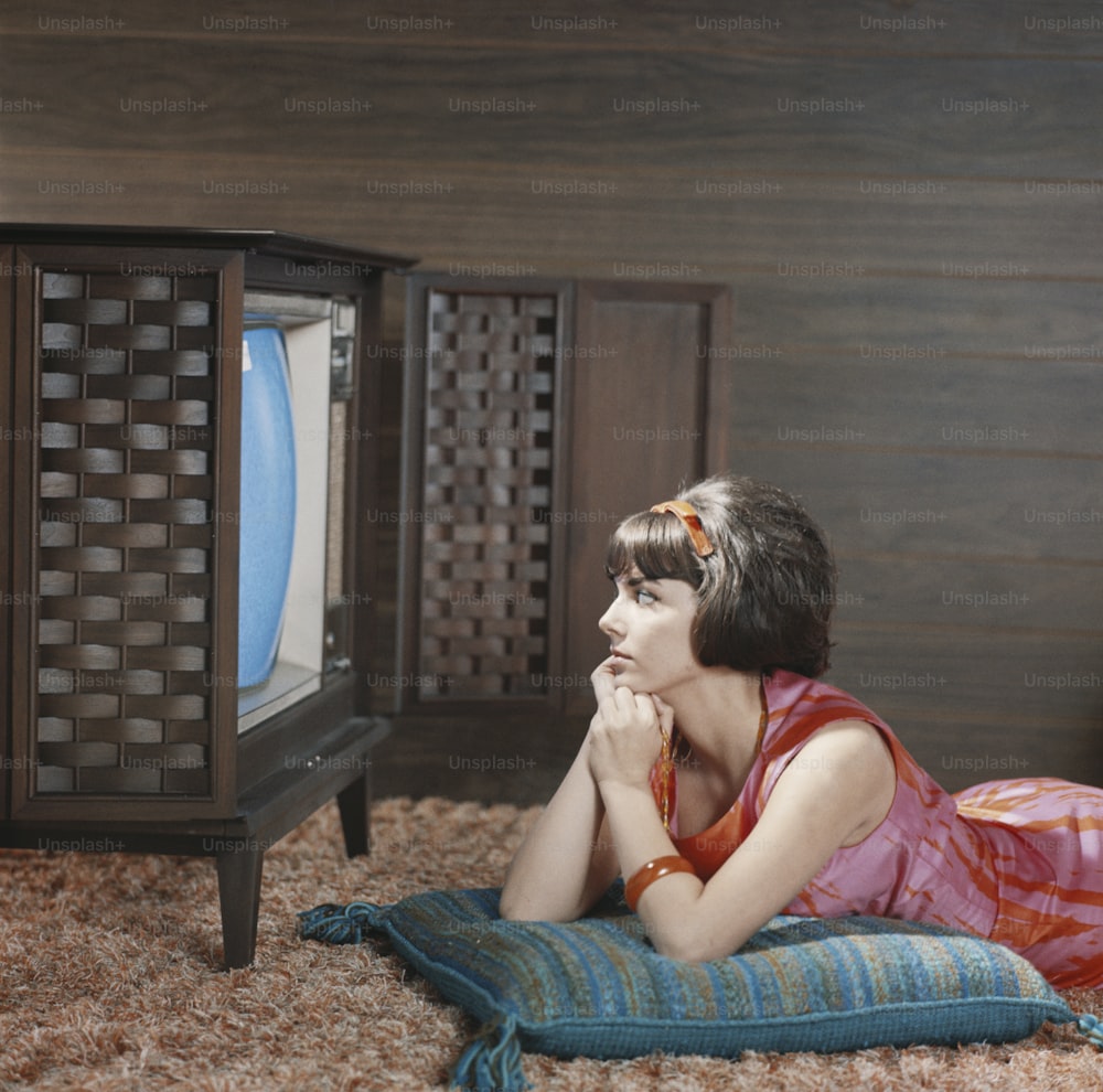 a woman laying on the floor in front of a television