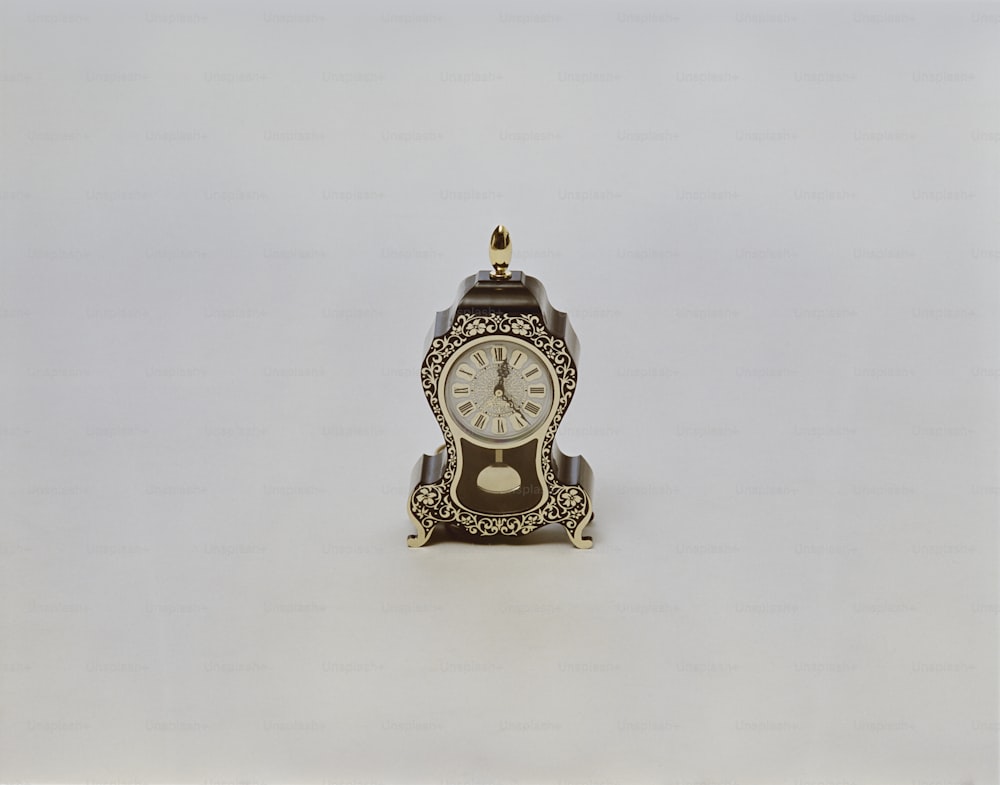 Un pequeño reloj sentado encima de una mesa