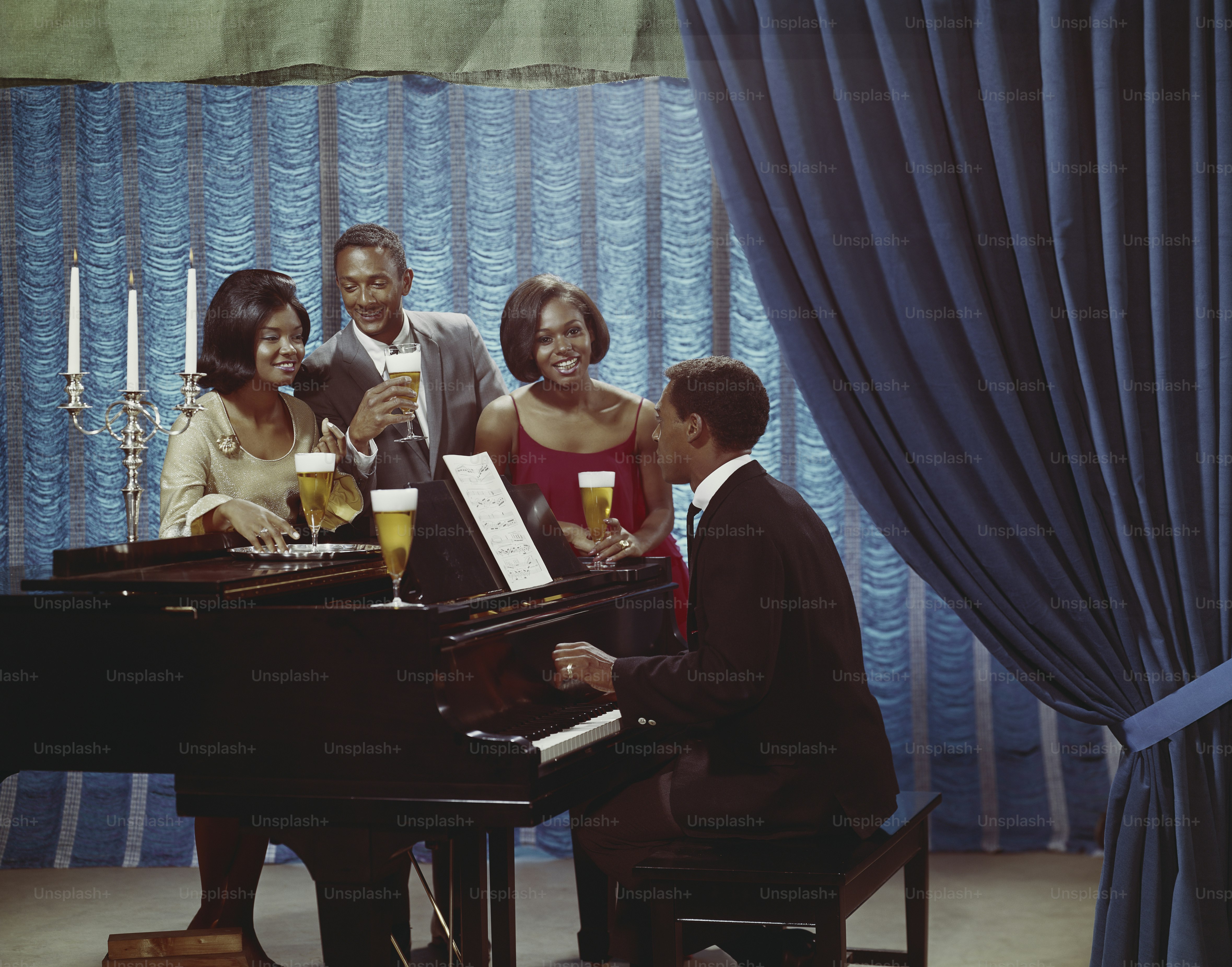 a group of people standing around a piano