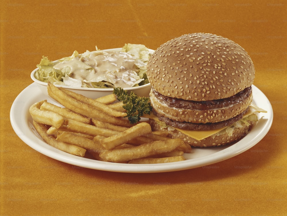 ein Teller mit einem Hamburger und Pommes darauf