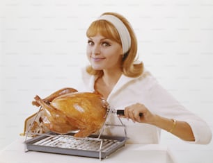 a woman holding a turkey in front of a keyboard