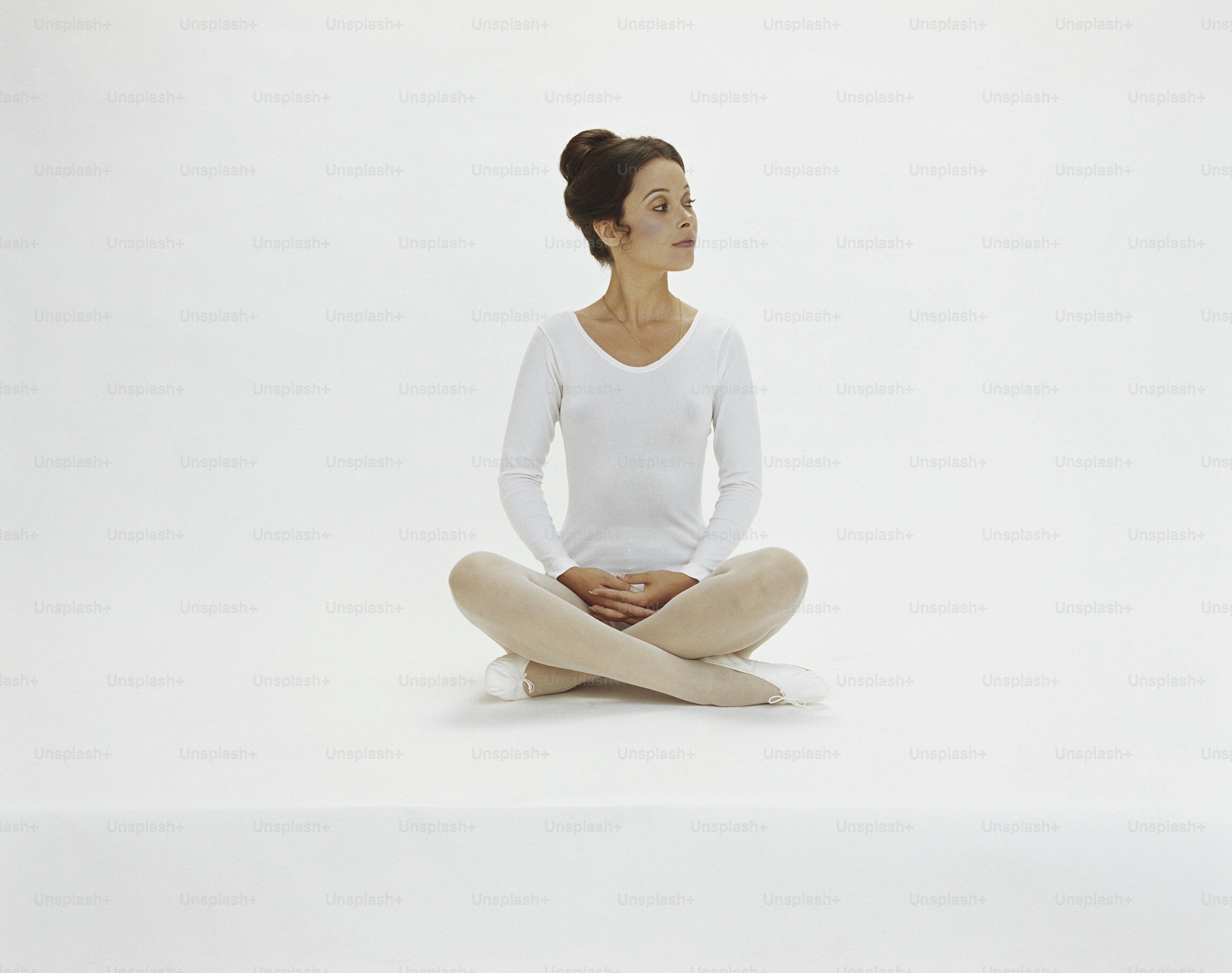 A woman sitting on the ground in a yoga pose photo – Adult Image on ...