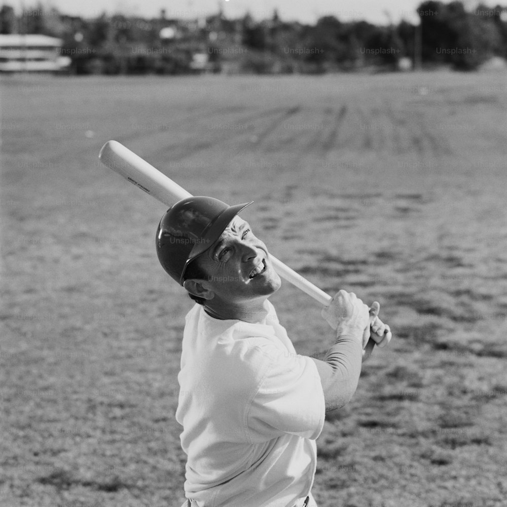 Una foto en blanco y negro de un jugador de béisbol sosteniendo un bate
