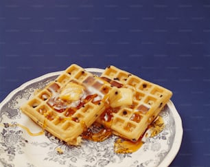 a plate with waffles and syrup on it