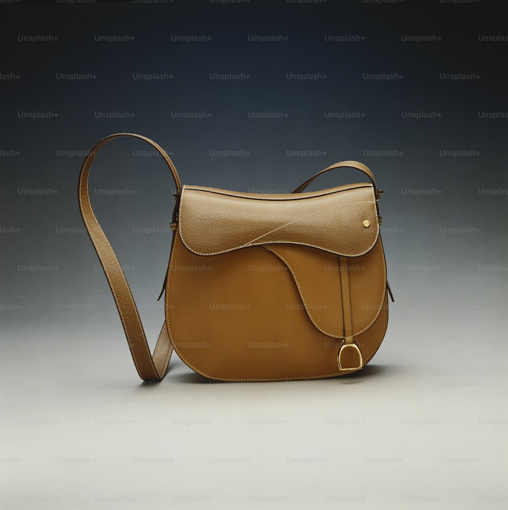 a brown leather purse with a long strap