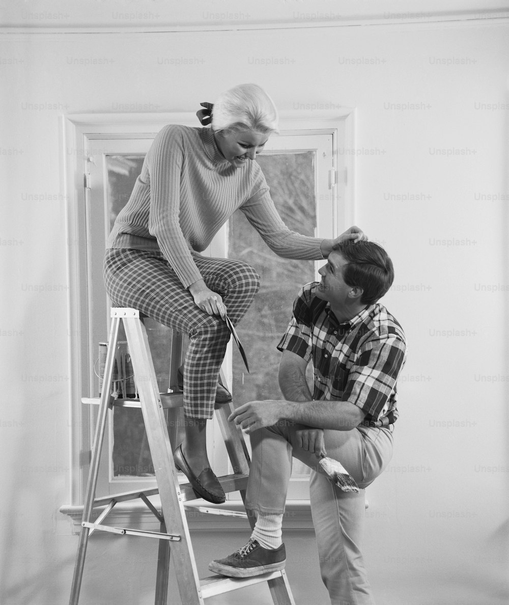 a man and a woman are sitting on a ladder