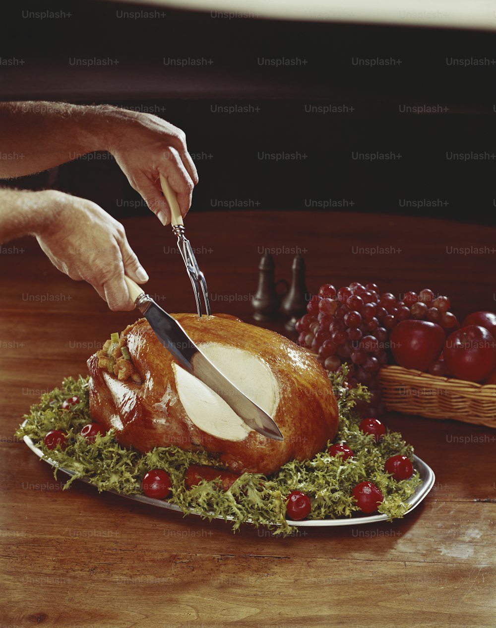 a person cutting a turkey on a platter