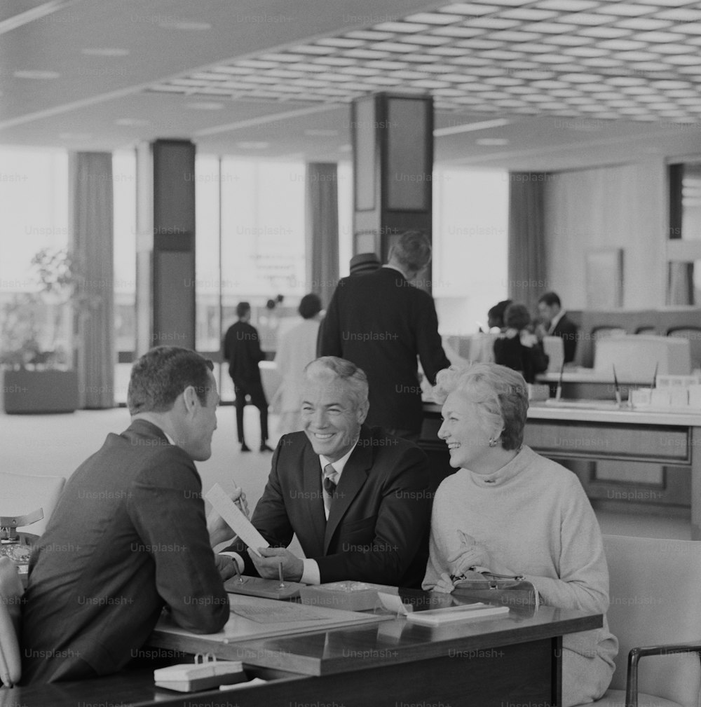 테이블에 앉아 있는 세 사람의 흑백 사진