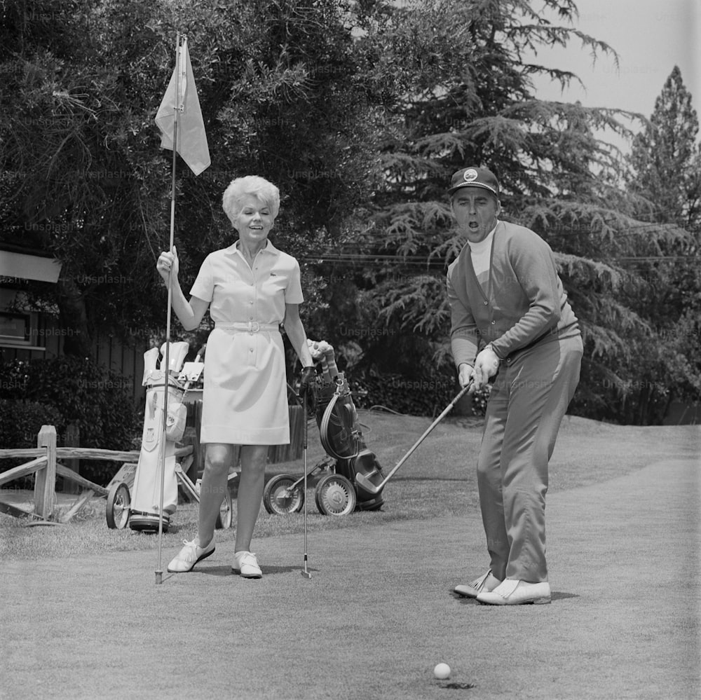 an old photo of a man and a woman playing golf
