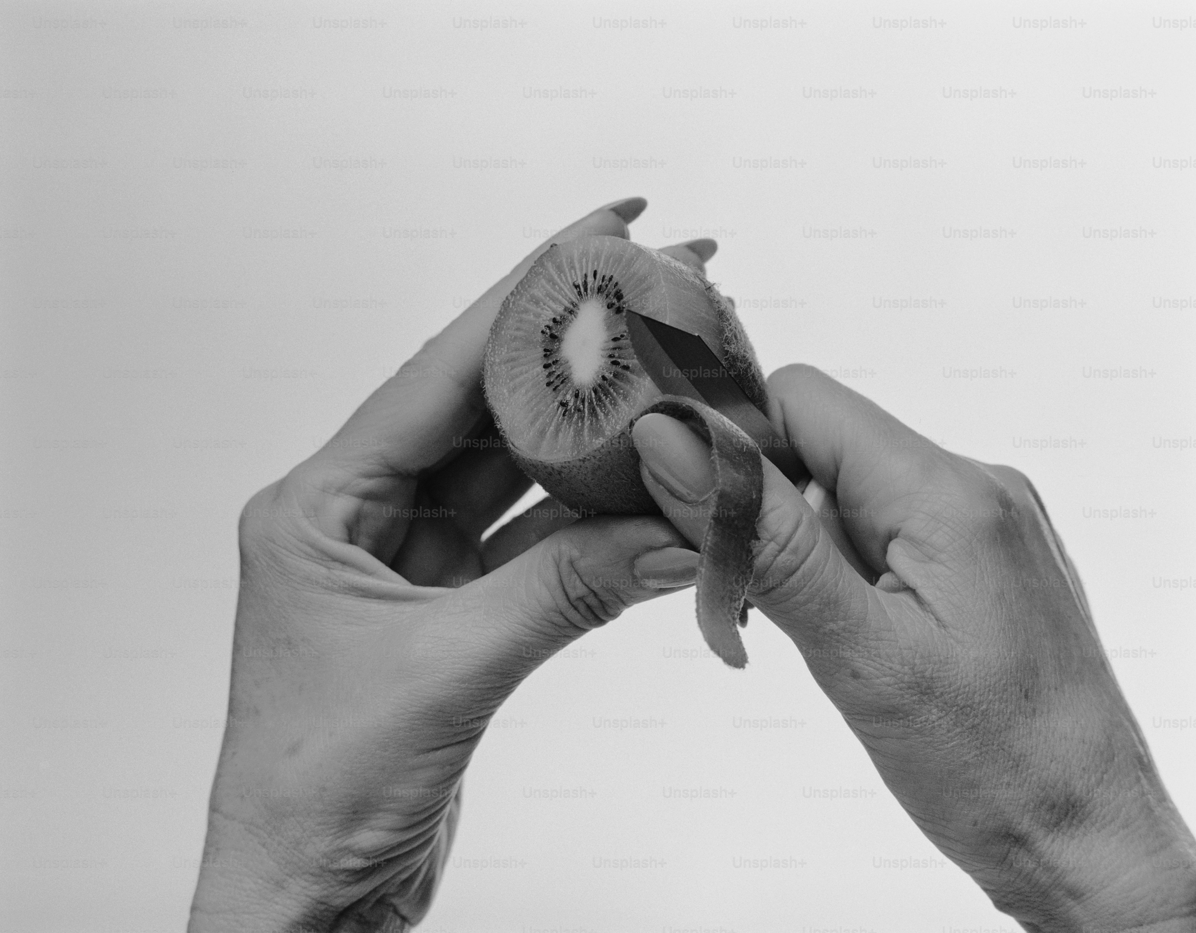 a person holding a half eaten kiwi fruit