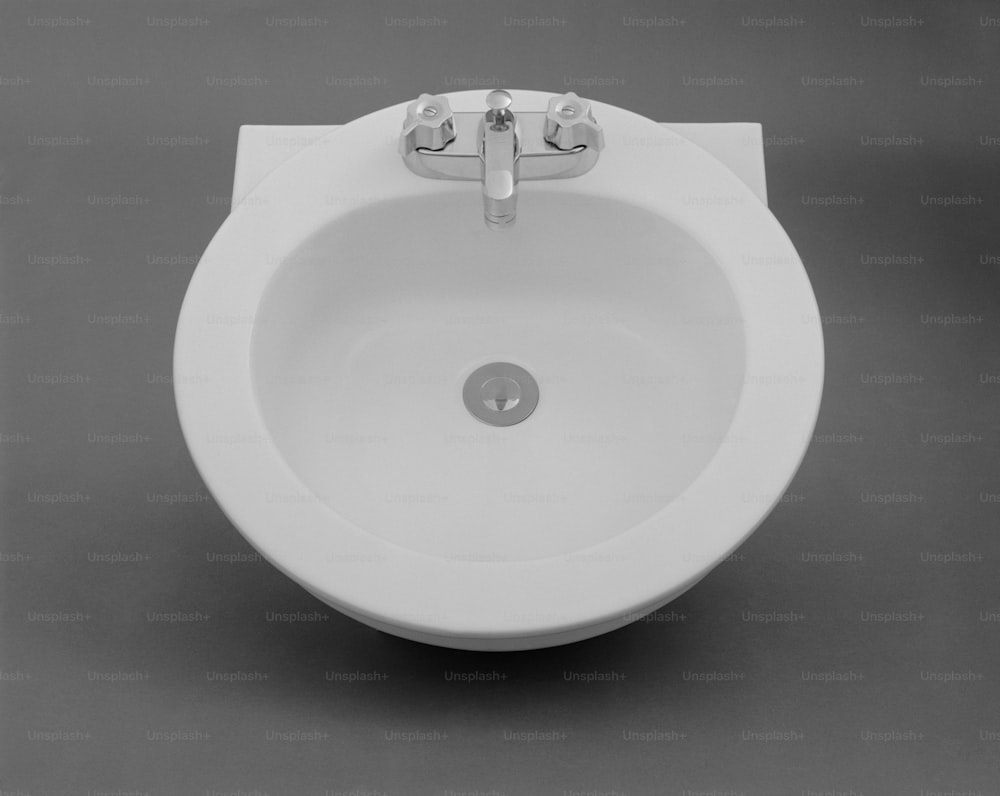 un lavello in porcellana bianca con rubinetto cromato