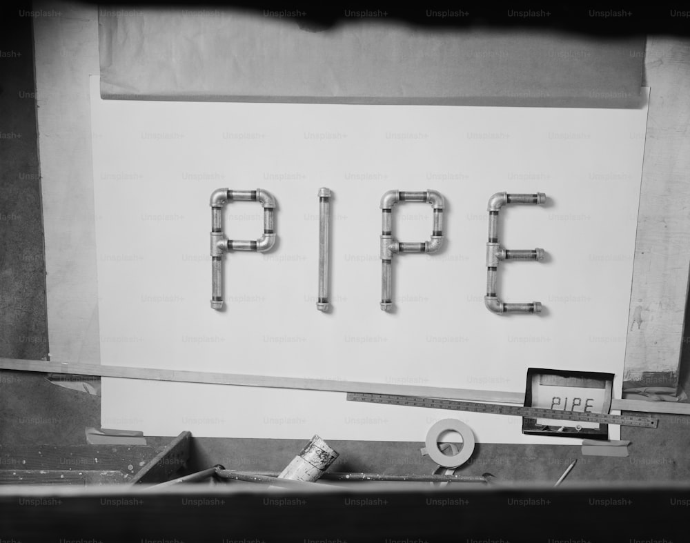 a black and white photo of pipes and a sign