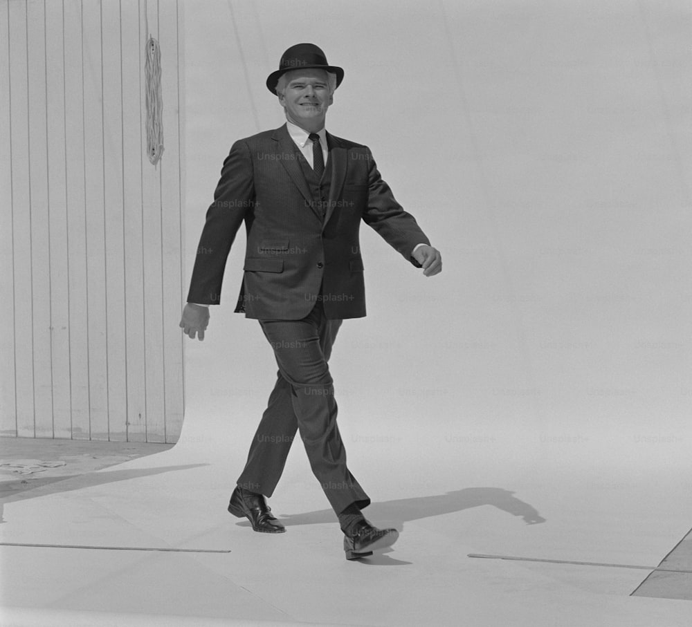 Una foto en blanco y negro de un hombre con traje y sombrero