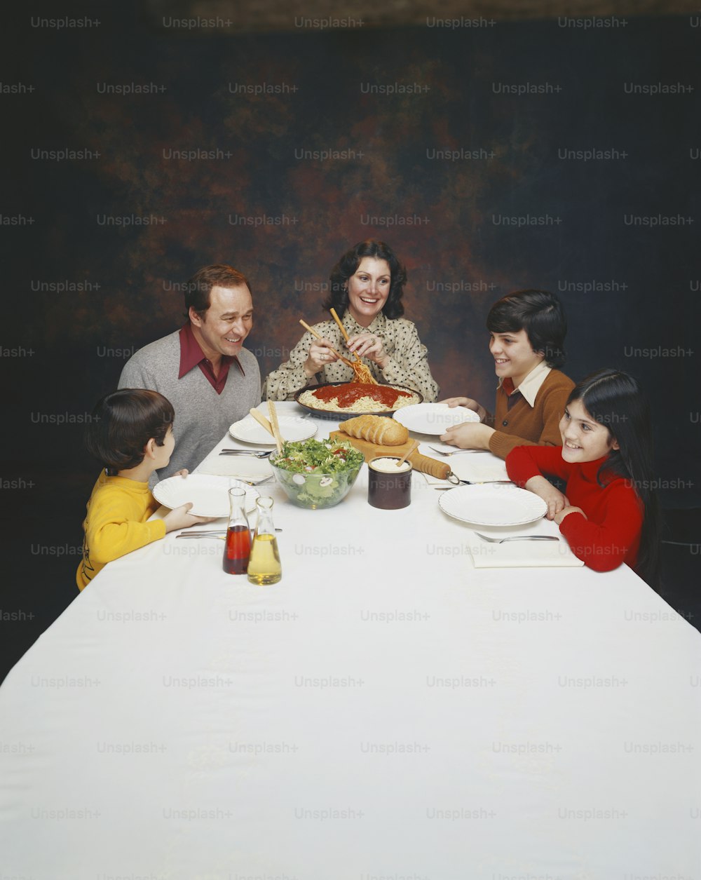 a group of people sitting around a white table