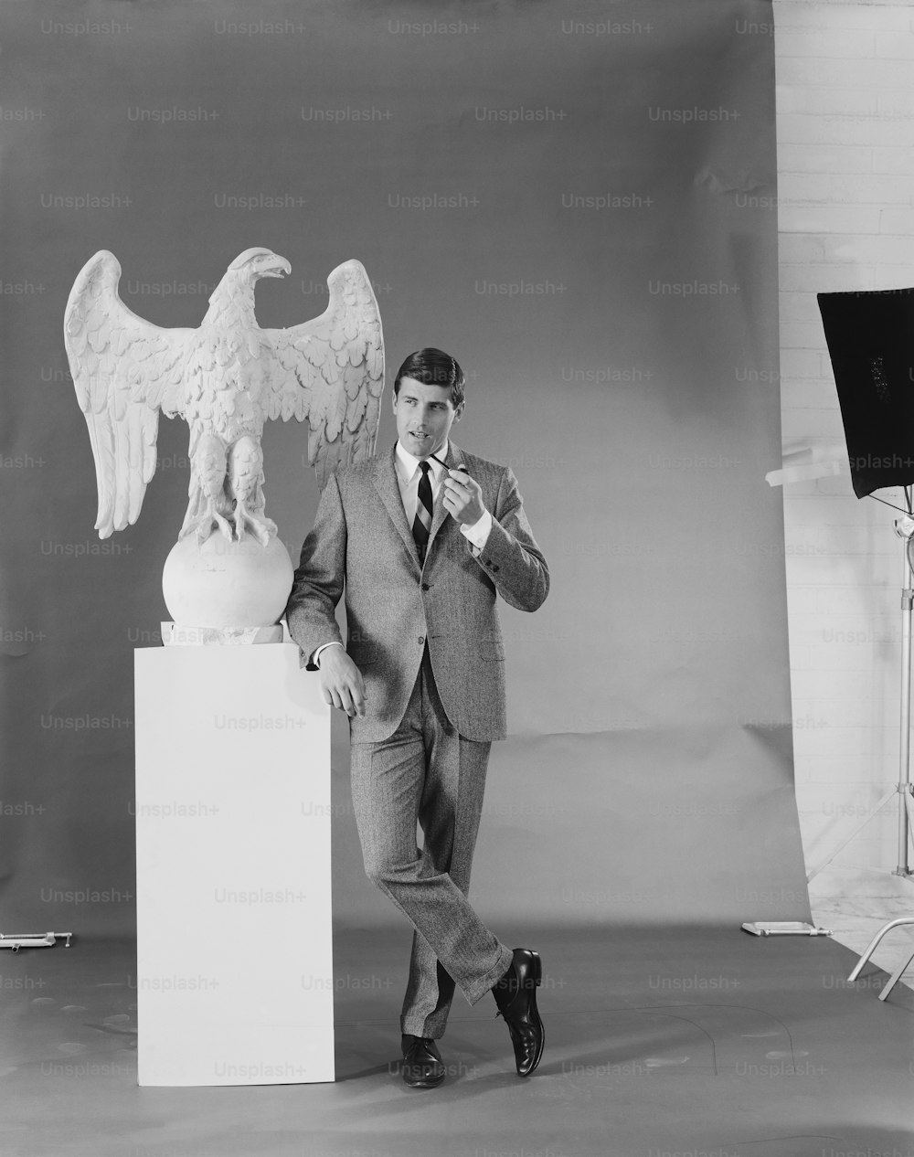 a man standing next to a statue of an eagle