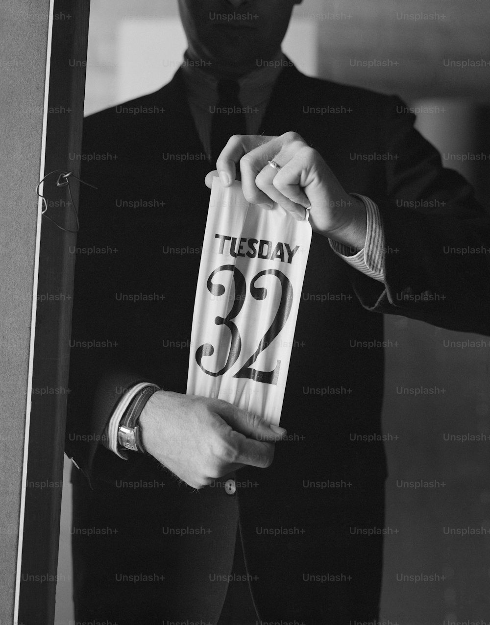 a man in a suit and tie holding a piece of paper