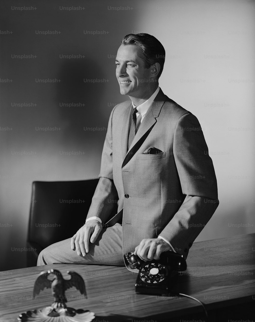 机�に座っている男性の白黒写真