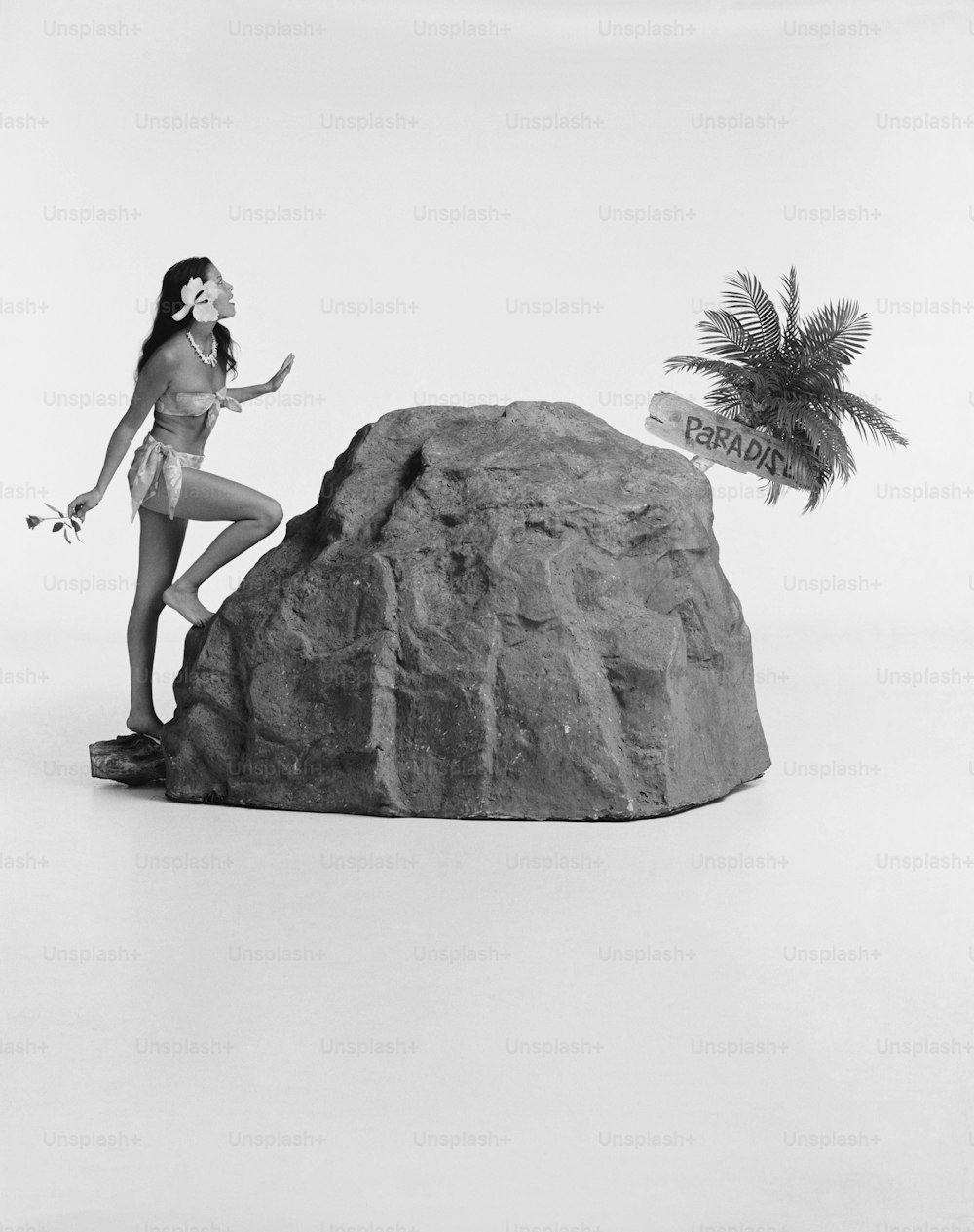 a woman in a bathing suit standing next to a rock