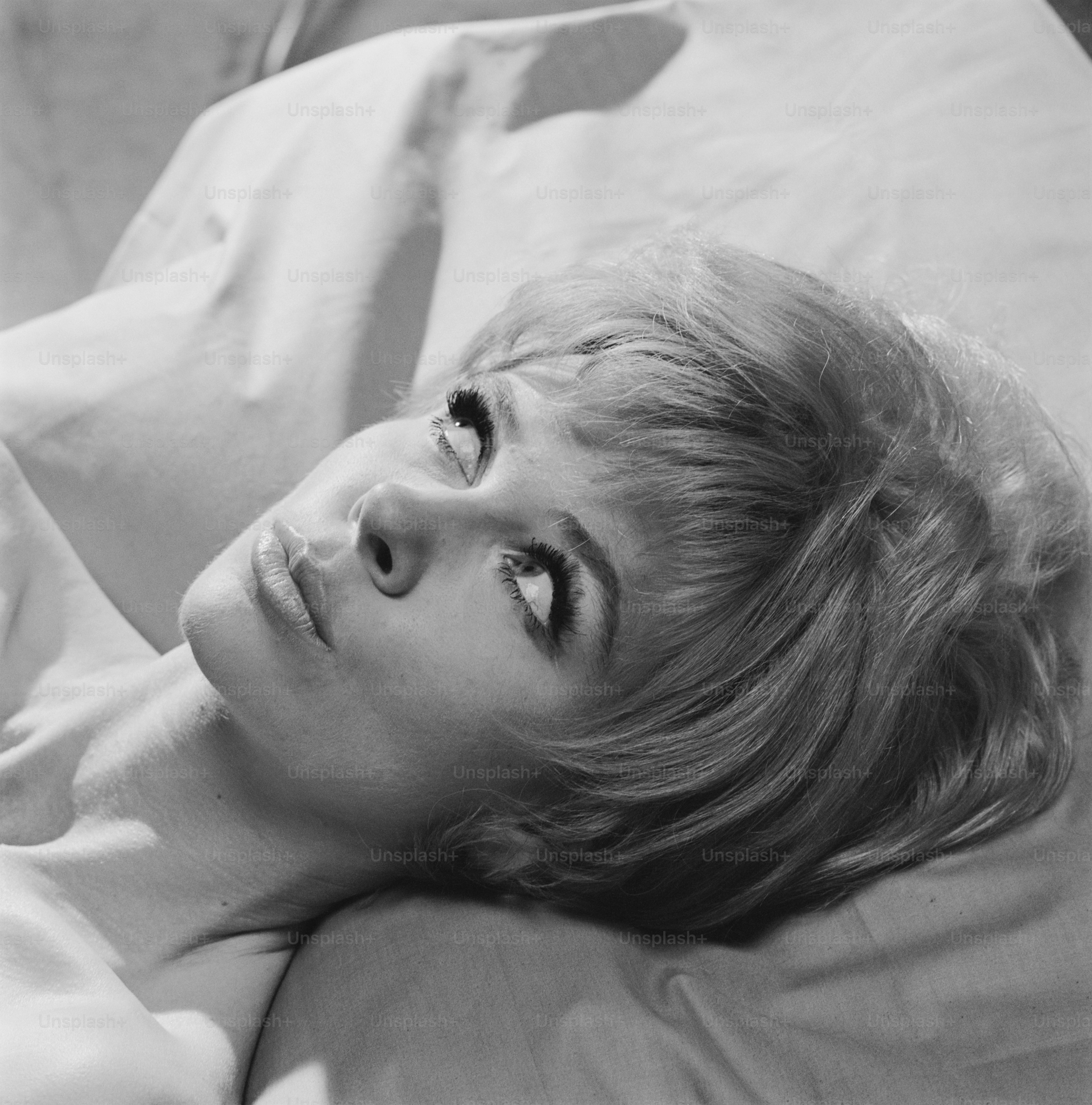 A black and white photo of a woman laying in bed photo – Looking up ...